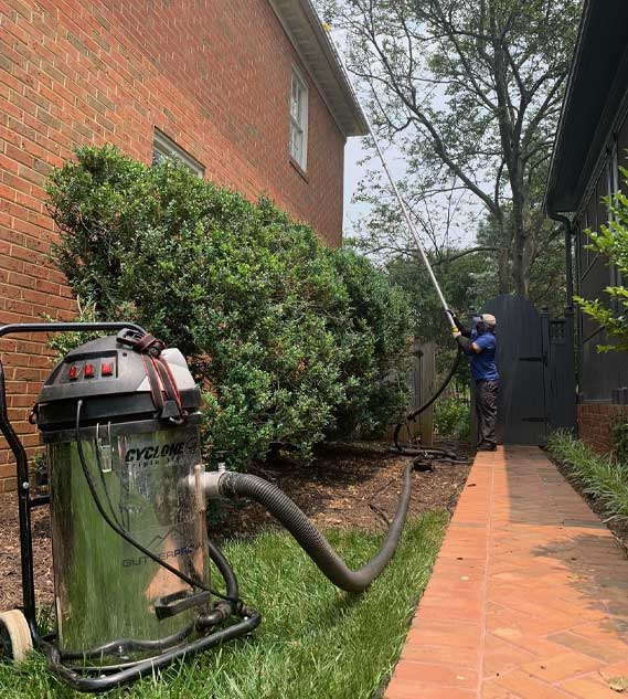 A person using the cyclone triple 3600 and 20 foot aluminum clamping pole with the silicon u-bend neck to clear the gutter of a house.