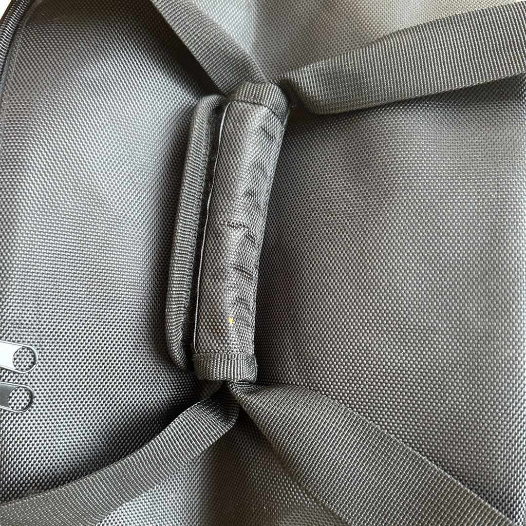 Close-up view of Cyclone vacuum hose bag’s padded handle and durable stitched straps from a top angle